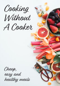 A book cover, the title of which is "Cooking Without a Cooker". Image shows healthy ingredients laid out on a table.
