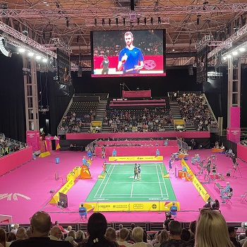 Commonwealth Games squash match inside court with pink surrounds and audience