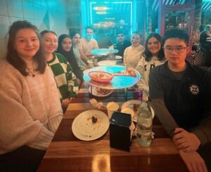 group photo of some of the Widening Participation society members, sitting at a wodden table in a restaurant