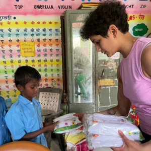 Saloni handing over hygiene products to a school boy.