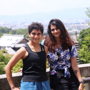 Saloni and her sister photographed with view of trees and houses behind them