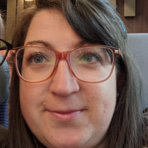 Agata Dunsmore smiling at camera, wearing glasses and brown hair.