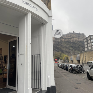 Exterior view of Assai Record Shop, door and signage with Edinburgh Castle in the background.