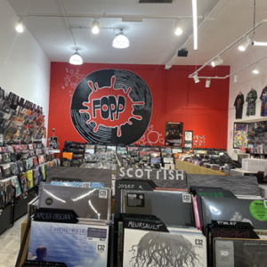 The interior of Fopp record store with rows of records and and t-shirts hanging on the wall.