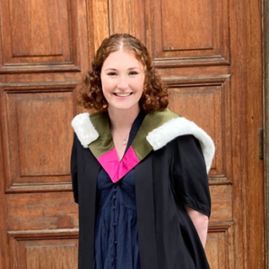 Medical student, Amberley standing in front of McEwan Hall doorway wearing graduation robes.