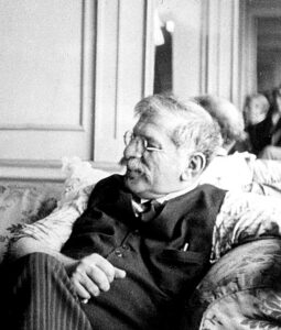 black white photo of Magnus as he sits on a couch and looks away from the camera