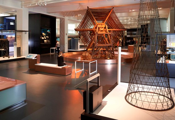 Photograph of the science museum information galleries. In the foreground a netted cone sits, in the background a large wooden telegraph wheel.