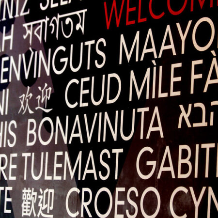 Picture of a multilingual "Welcome" sign that uses unusual languages.