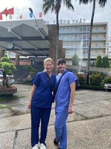 Una and another student stand together outside the hospital in Vietnam