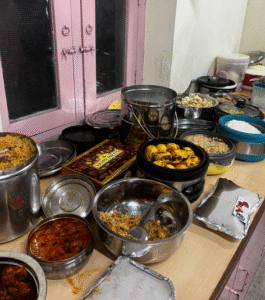 A kitchen counter displaying numerous pots and pans filled with food.