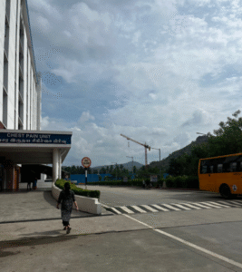 A person crosses the street in front of a building, highlighting a typical city scene.