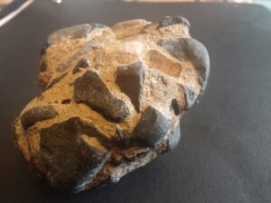 A small rock - it looks like it is made up of pebbles stuck together with cement