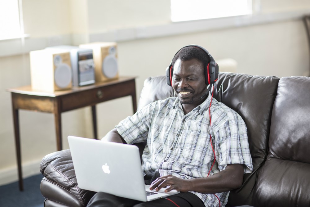 man wearing headphones on laptop