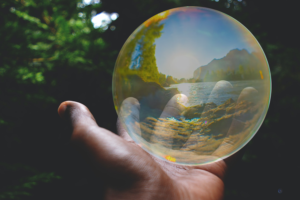 A bubble in a person's palm, with trees in the background