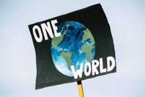 A placard with a picture of the Earth and the words "ONE WORLD"