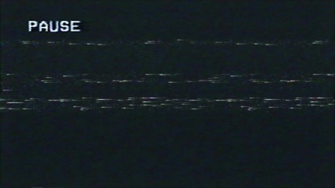 image shows a distorted VHS pause screen