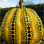 A giant pumpkin with neatly arranged polka dots on its surface.