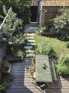 The garden has a distinctly recreational character. Organically shaped borders filled with richly flowering perennials and ornamental grasses provide a natural appearance. This character is enhanced by interlocking stepping stones in the grass and dry stone walls of old tiles and stones.