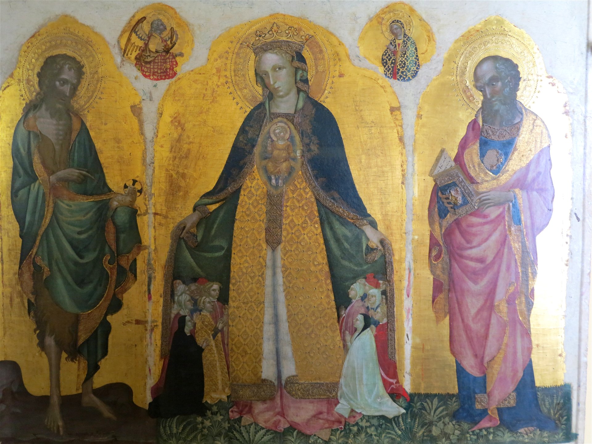 A religious artwork depicting three haloed figures against a gold background: a Mary and Jesus at the center, flanked by two bearded men.