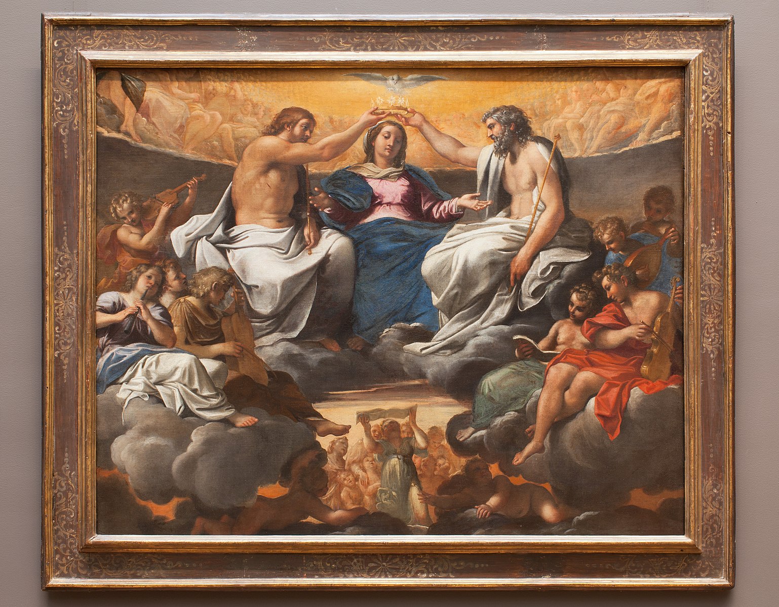 A classical painting of a religious scene with the Madonna being crowned by Jesus and God, surrounded by angels and cherubs.