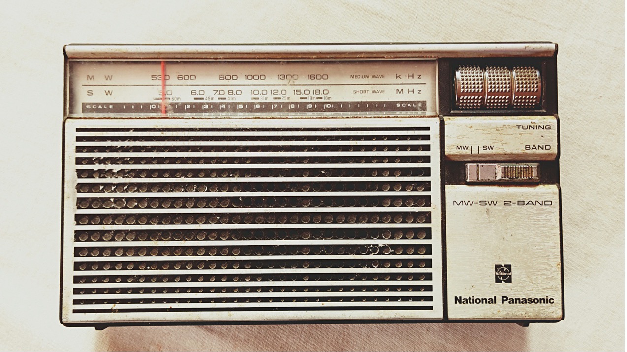 A vintage National Panasonic MW-SW 2-band radio, symbolizing classic audio storytelling and radio drama.