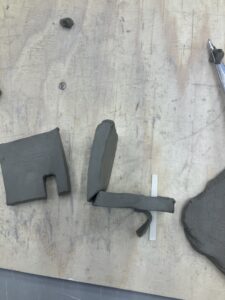 two clay squares are standing upright, perpendicular to one another. You can see that a diagonal line has been cut downwards to aid the joining process. 