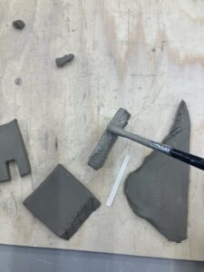 A paintbrush is being used to apply slip to the crosshatched sides.