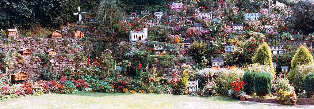 an image of a standard model village with various miniature houses on a small craggy hill.