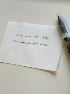 It's a blank piece of paper with the words write down the things that make you feel anxious. A gel pen is placed on the right side of the paper.