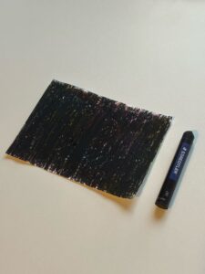 This is a piece of paper covered with black oil pastels, with a hint of color in the black.