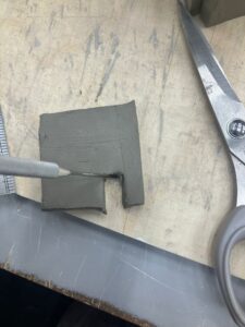 A needle point tool is being used to neaten up the doorway shape.