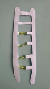A broken paper ladder fixed with green rope