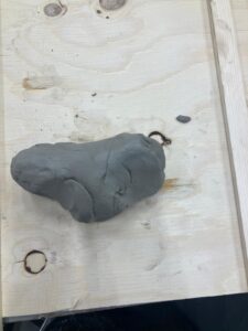 a lump of clay that is beginning to form into a 'ram's head' shape due to following the wedging process. 