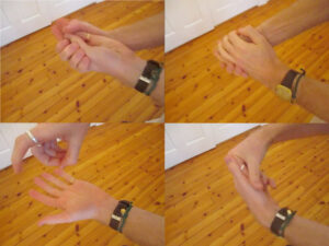 Four images with identical composition show two disembodied hands and forearms acting out the act of washing one's hands, at different stages of the washing: including scrubbing and squeezing soap onto the hands.