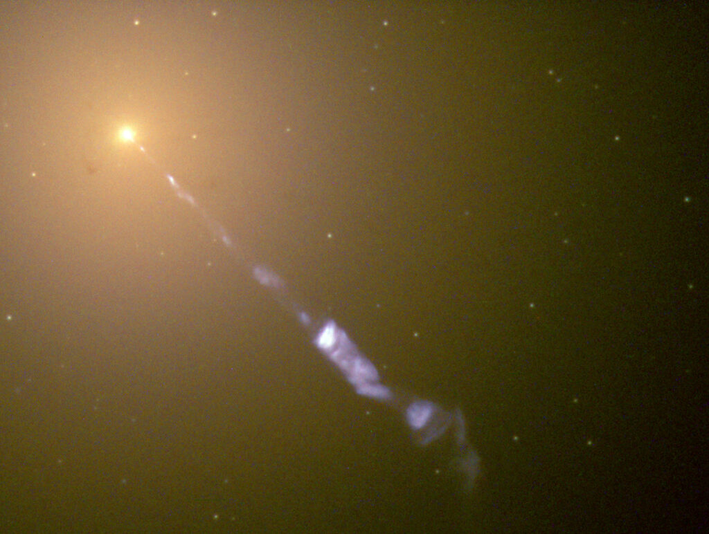 Image taken by the Hubble Space Telescope of a 5000-light-year-long jet ejected from the active galaxy M87. The blue synchrotron radiation contrasts with the yellow starlight from the host galaxy.