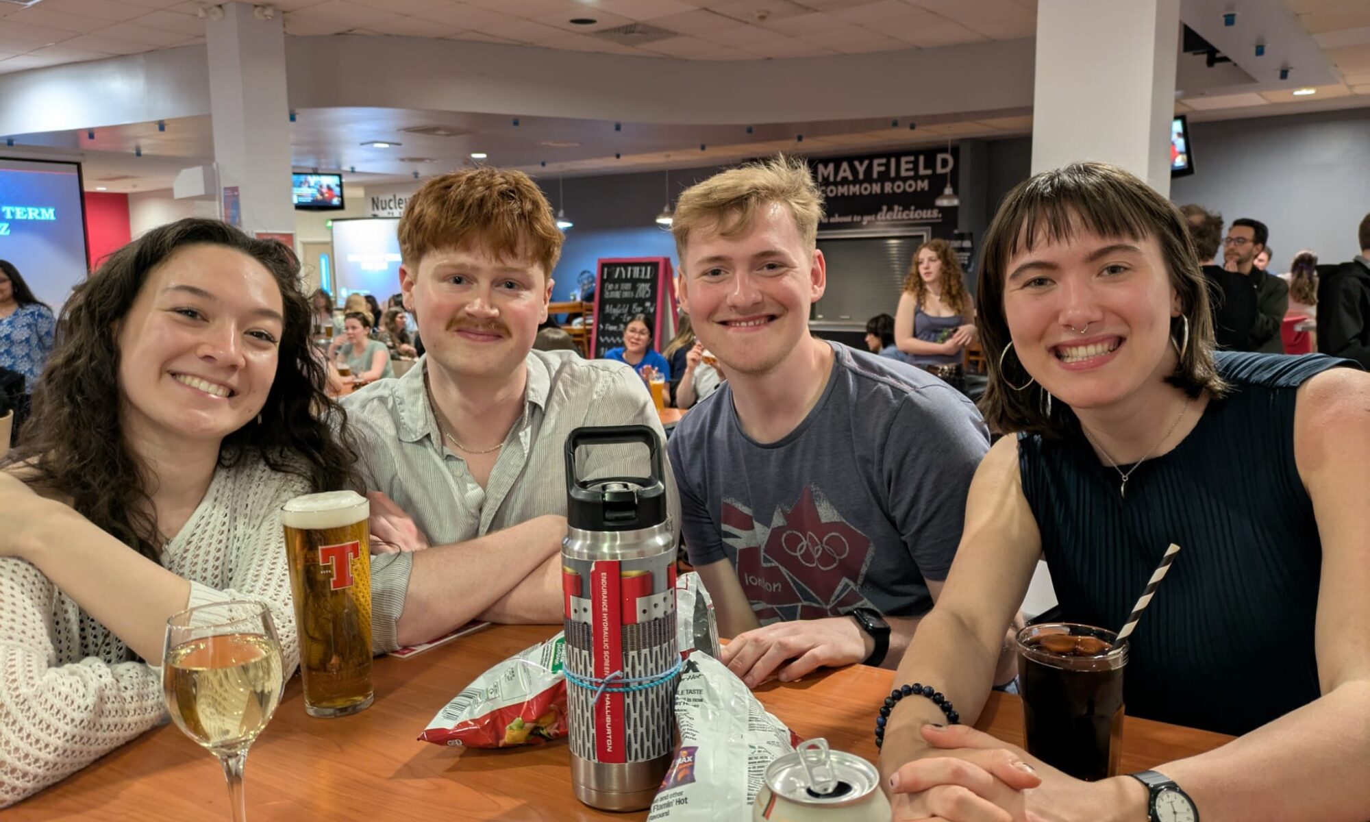 Four students (including Cate) gathered round table in student union pub.
