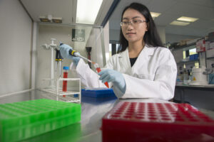 PhD student using a pipette in a lab