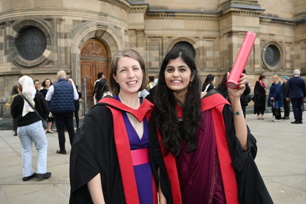 Two graduates in front of the McEwan Hall