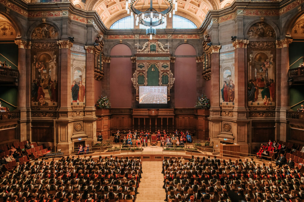 The ornate McEwan Hall full of graduates, with staff in full academic dress on the stage.