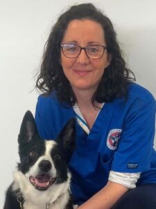 Amy Mielse in clinical scrubs with a dog