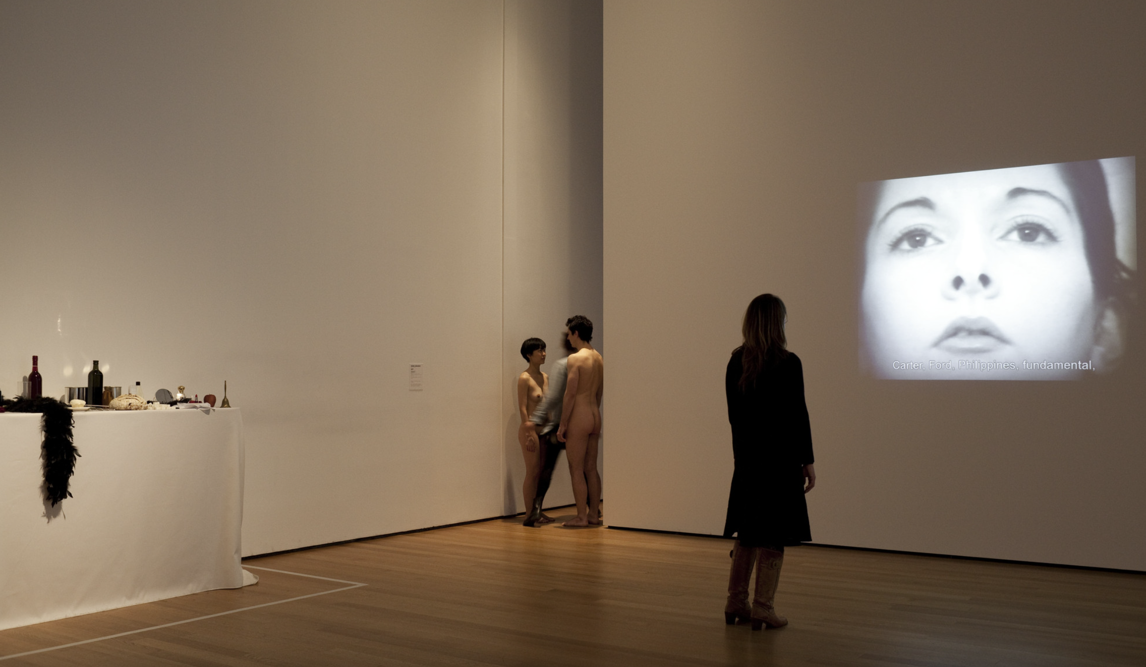 Two naked people form a space, and pedestrians need to pass through them.