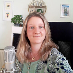 Lana Woolford at her desk with a microphone in a the foreground