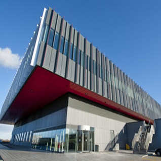 Grey and red building with blue sky background