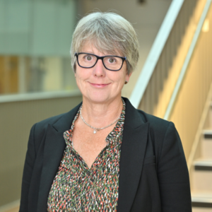 corporate headshot of Gill smiling looking into the camera