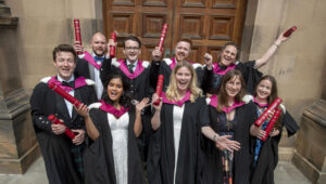 Happy HCP-Med graduates in robes in front of MacEwan Hall.