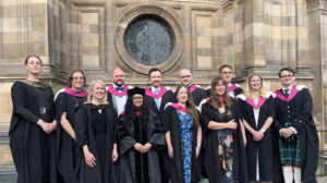 A group of HCP Med graduates in their gowns outside MacEwan Hall.