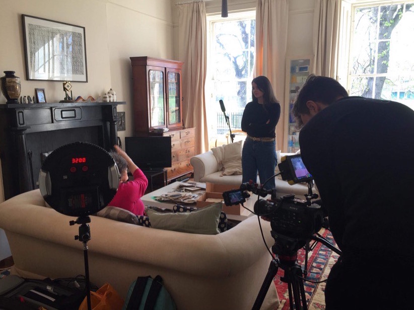 Kezia, a colleague and an interviewee in a living room with filming equipment.
