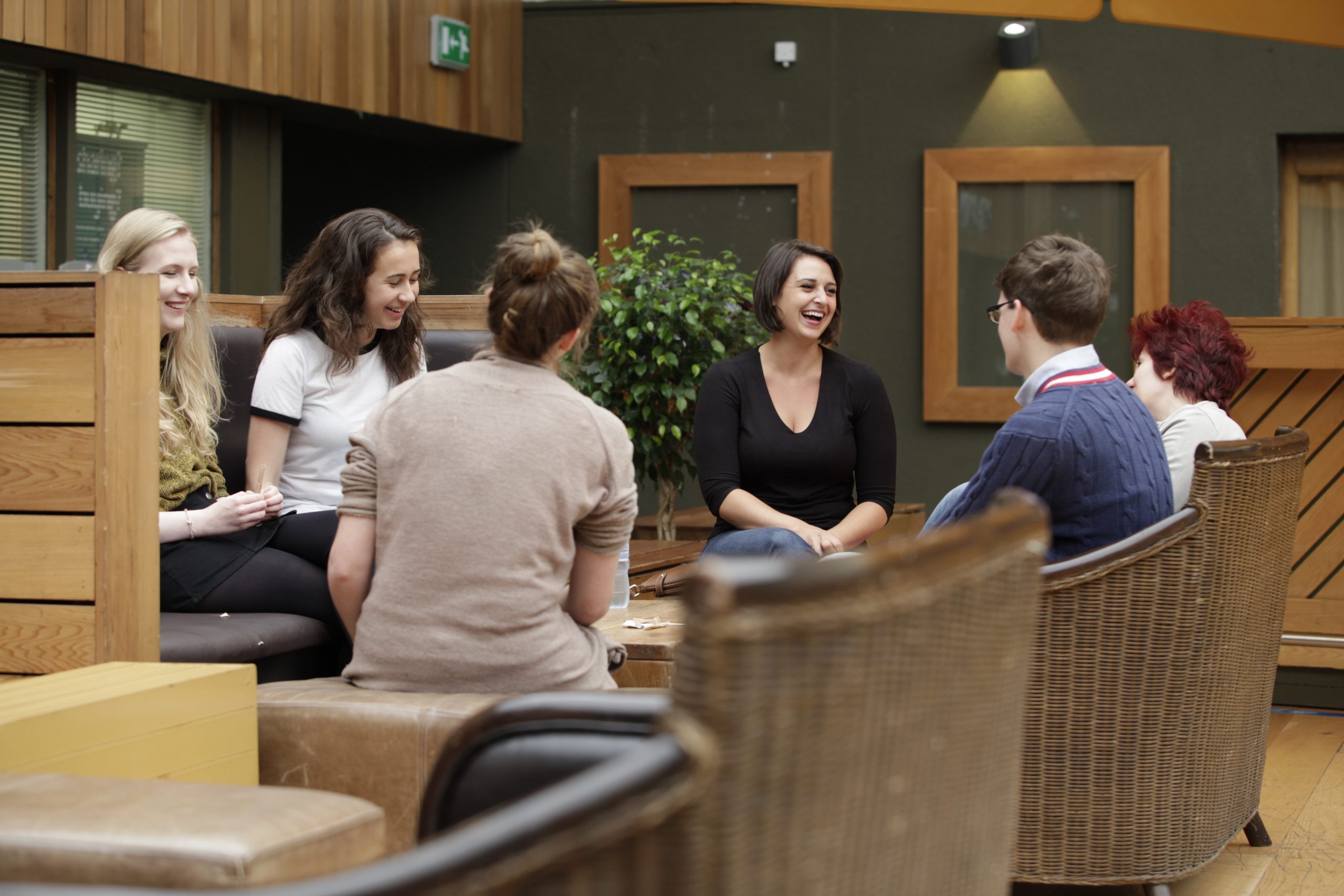 A group of students of different ages sit together chatting