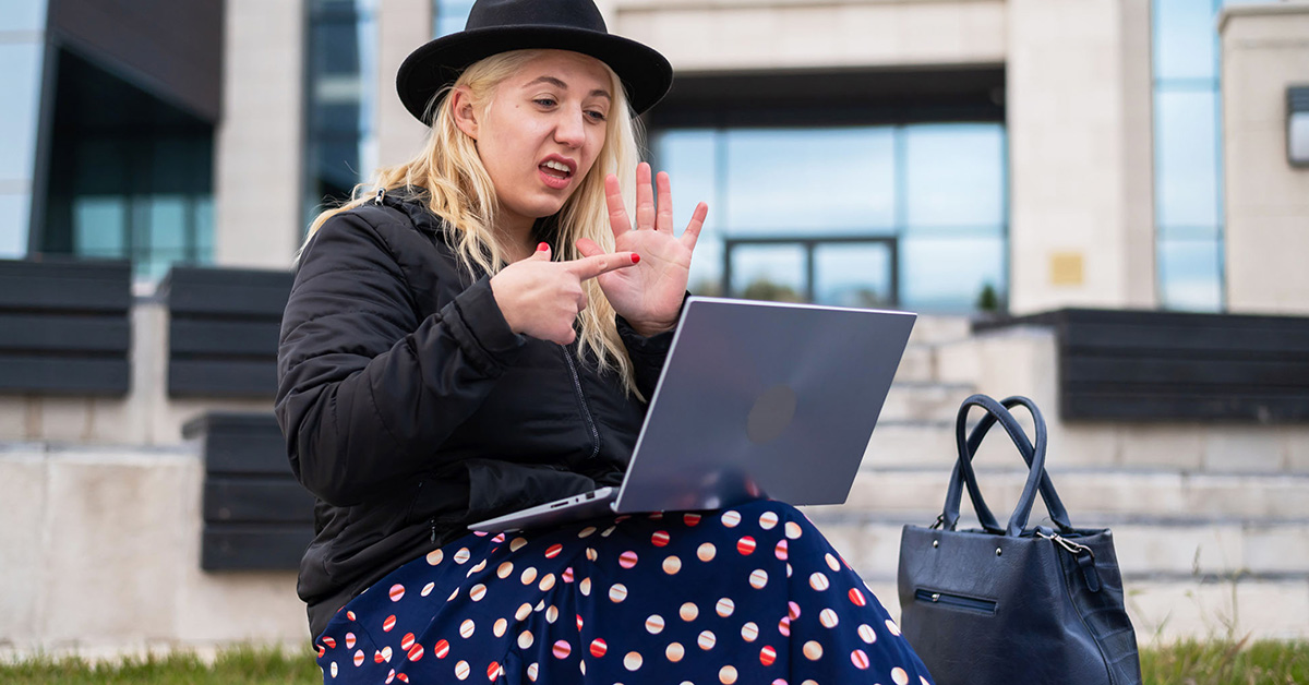 A female student uses BSL on an online call