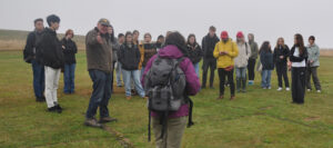 Professor Ian Ralston (baseball cap at left) describes Doon Hill, to students